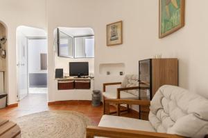 a living room with a couch and a television at A27 - Caracol Corner Studio in Lagos in Lagos