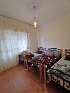 two twin beds in a room with a window at Jubeiha Home in Amman