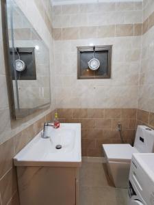 a bathroom with a sink and a toilet and a mirror at Jubeiha Home in Amman +14 photos