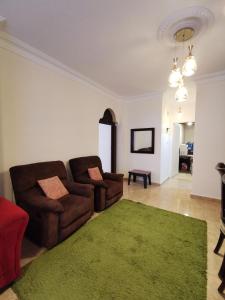 a living room with a couch and a green rug at Jubeiha Home in Amman
