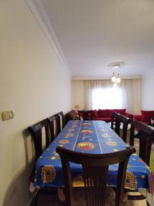 a dining room with a blue table and chairs at Jubeiha Home in Amman