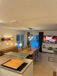 a kitchen and living room with a table and a tv at 4 Zimmer Ostseetraum in Gneversdorf