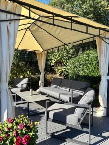 a patio with chairs and a table and an umbrella at 4 Zimmer Ostseetraum in Gneversdorf