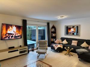 a living room with a couch and a tv at 4 Zimmer Ostseetraum in Gneversdorf