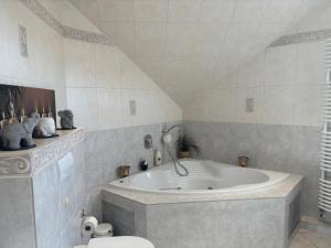 a bathroom with a bath tub and a toilet at 4 Zimmer Ostseetraum in Gneversdorf +7 photos