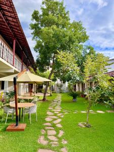 ein Garten mit Tisch und Stühlen und einem Baum in der Unterkunft Antolina Hotel in Goiás