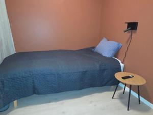 a bedroom with a blue bed and a table at Aurora Andøya Suites in Andøya