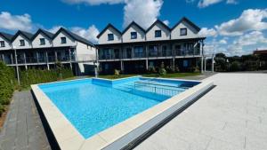 a large house with a swimming pool in front of it at Apartament Ksawery parking w cenie podgrzewany basen in Rewal