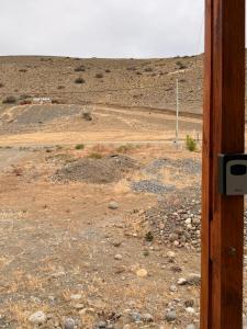 a view of a dirt field from a window at frente del mirador in Tres Lagos