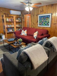 a living room with a red couch and a table at Algonquin Waterfront and Winter Paradise With Sunsets in Algonquin Highlands