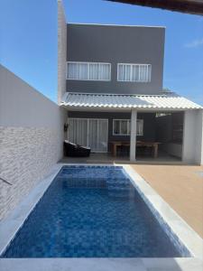 a house with a swimming pool in front of a house at Gran Reserva Maragogi in Maragogi