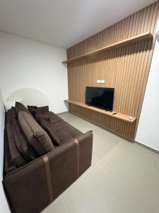 a living room with a couch and a flat screen tv at Gran Reserva Maragogi in Maragogi