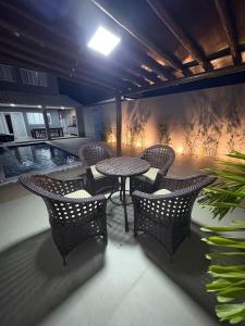 a patio with a table and chairs and a pool at Gran Reserva Maragogi in Maragogi