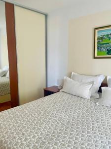 a bedroom with a large bed with white pillows at Apartment Mandarina in Dugi Rat
