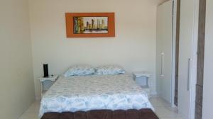 a bedroom with a bed with a picture on the wall at Praia com Conforto in Guaratuba +55 photos