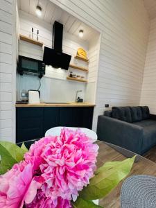 a pink flower sitting on a table in a living room at Котедж RIVERHILL 2-4 осіб in Slavske