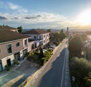 a street in a town with houses and cars at Al Ventisei - Azzurro in Treiso