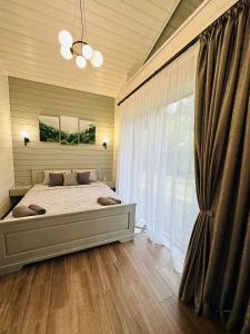 a bedroom with a bed and a large window at Котедж RIVERHILL 2-4 осіб in Slavske