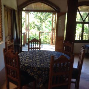 a dining room with a table and chairs and a balcony at Casa Cafetal Coatepec in Coatepec
