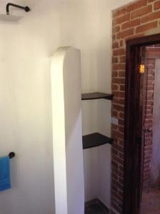 a shelf in a room with a brick wall at Casa Cafetal Coatepec in Coatepec