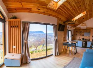 a living room with a large glass door with a view at Royal Hill Bran-A-Frame and Bungalows whit Hot Tub and Sauna in Sohodol