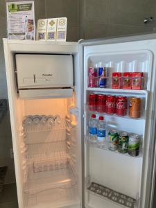 an open refrigerator filled with drinks and soda cans at Residencial T&D V AP 501 - À 5min do Centro e Faculdades in Mossoró
