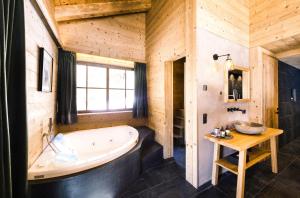 a large bathroom with a tub and a table at Mons Silva Private Luxury Chalets in Racines +31 photos