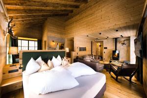 a bedroom with a bed and a living room at Mons Silva Private Luxury Chalets in Racines