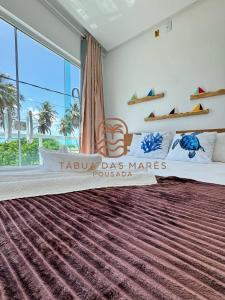 a bedroom with a large bed with a large window at Pousada Tábua das Marés in Japaratinga +23 photos