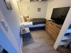 a small room with a bed and a flat screen tv at Tiny Ferienhaus Rathenaustrasse in Reichenbach im Vogtland