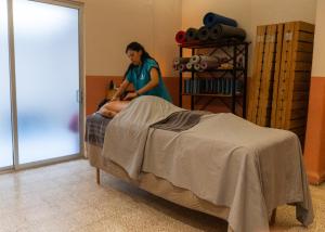 a woman standing next to a bed with a man at Selina Oaxaca in Oaxaca City