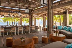 a bar at the beach with tables and chairs at The St. Regis Le Morne Resort, Mauritius in Le Morne