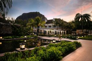 a resort with a pool and a mountain in the background at The St. Regis Le Morne Resort, Mauritius in Le Morne