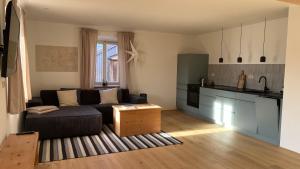 a living room with a couch and a kitchen at Maiergschwendter-Hof inkl. Chiemgaukarte in Ruhpolding