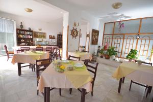 restauracja ze stołami i krzesłami z żółtą tkaniną w obiekcie Hotel Vila Margot w mieście Herceg Novi