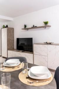a dining room table with white plates on it at Apartamento Ponent Stays in Almacellas