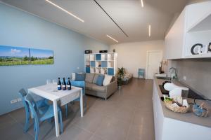 a kitchen and living room with a table and a couch at Al Ventisei - Azzurro in Treiso
