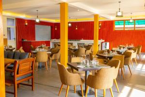 a restaurant with tables and chairs and red walls at Fort Arch Eco-Lodges in Fort Portal