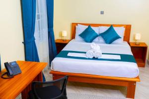 a bedroom with a bed with a desk and a telephone at Fort Arch Eco-Lodges in Fort Portal +11 photos