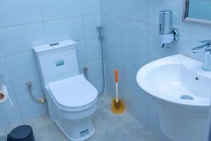 a bathroom with a white toilet and a sink at Fort Arch Eco-Lodges in Fort Portal