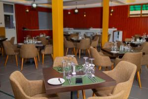 a dining room with tables and chairs in a restaurant at Fort Arch Eco-Lodges in Fort Portal