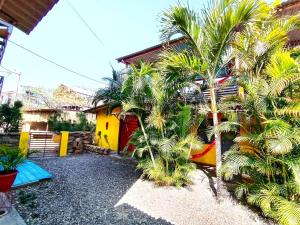 a house with palm trees in front of it at Casa Naranja in Máncora
