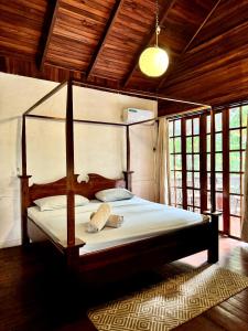 a bedroom with a canopy bed in a room with windows at Hotel Mandacarú Puerto Viejo in Puerto Viejo +39 photos
