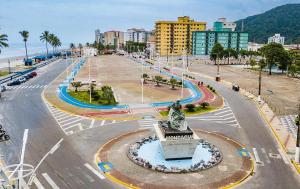 a city with a statue in the middle of a street at Apartamento no centro de Mongaguá in Mongaguá