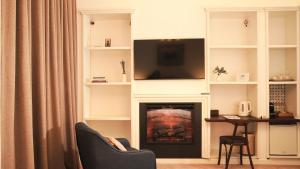 a living room with a fireplace with a flat screen tv at Weiss Central Boutique in Braşov