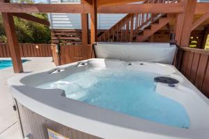 a jacuzzi tub on a deck with a staircase at 2058 - Blessed by the Sea Duck in Duck