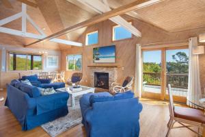 a living room with blue couches and a fireplace at 2058 - Blessed by the Sea Duck in Duck