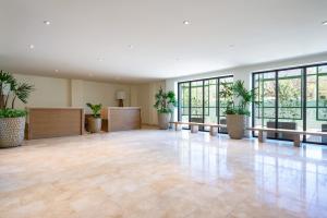 an empty lobby with potted plants and tables and windows at Zantamar 105B, a pie de playa in Cruz de Huanacaxtle +29 photos