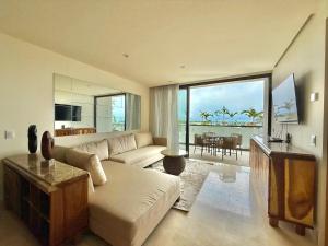 a living room with a couch and a table with a view at Zantamar 105B, a pie de playa in Cruz de Huanacaxtle