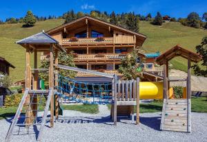 a playground in front of a log house at Appartements Liebe Heimat in Saalbach-Hinterglemm